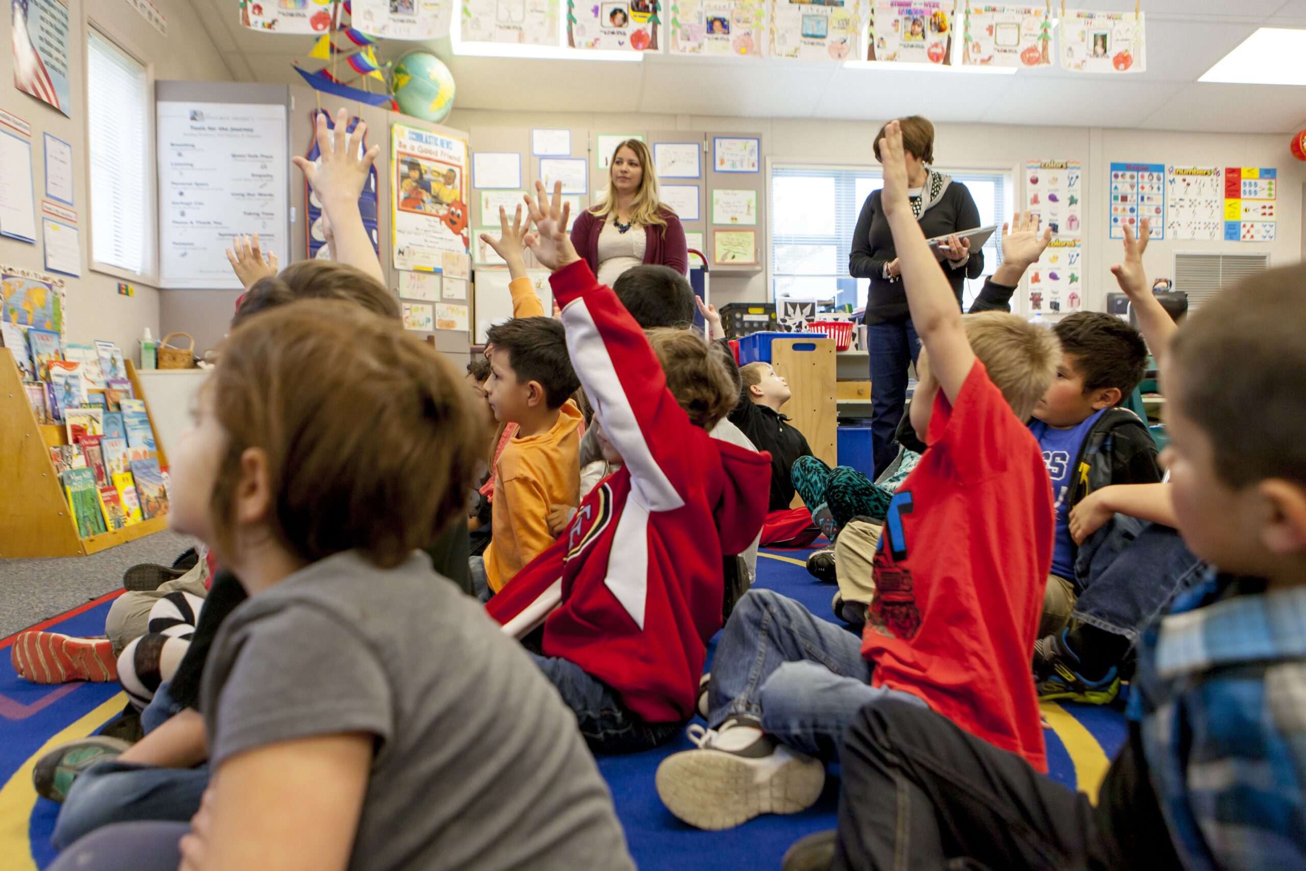 students sitting hands raised